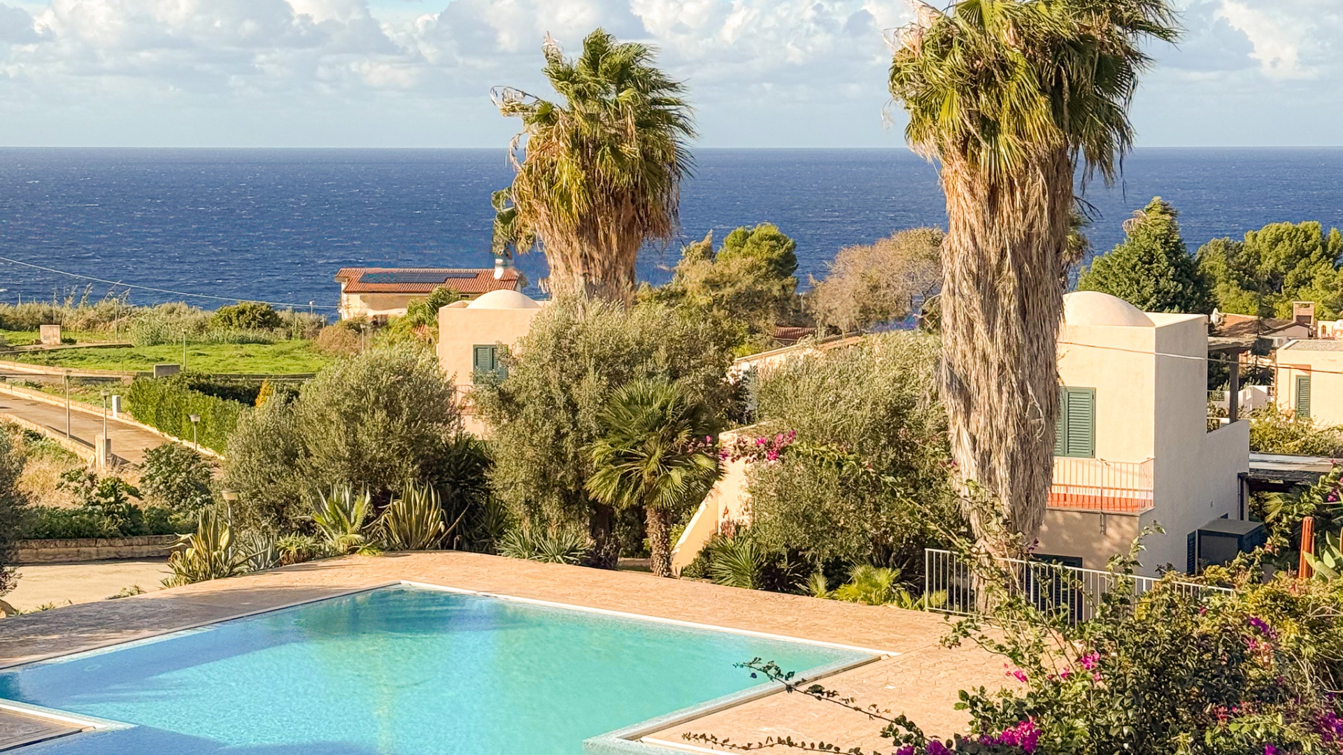 Piscina e palme vista mare